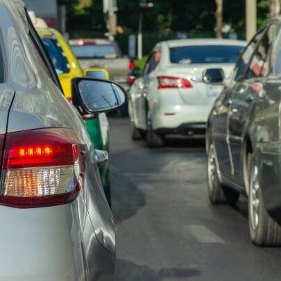 A bunch of cars that are parked on the side of the road